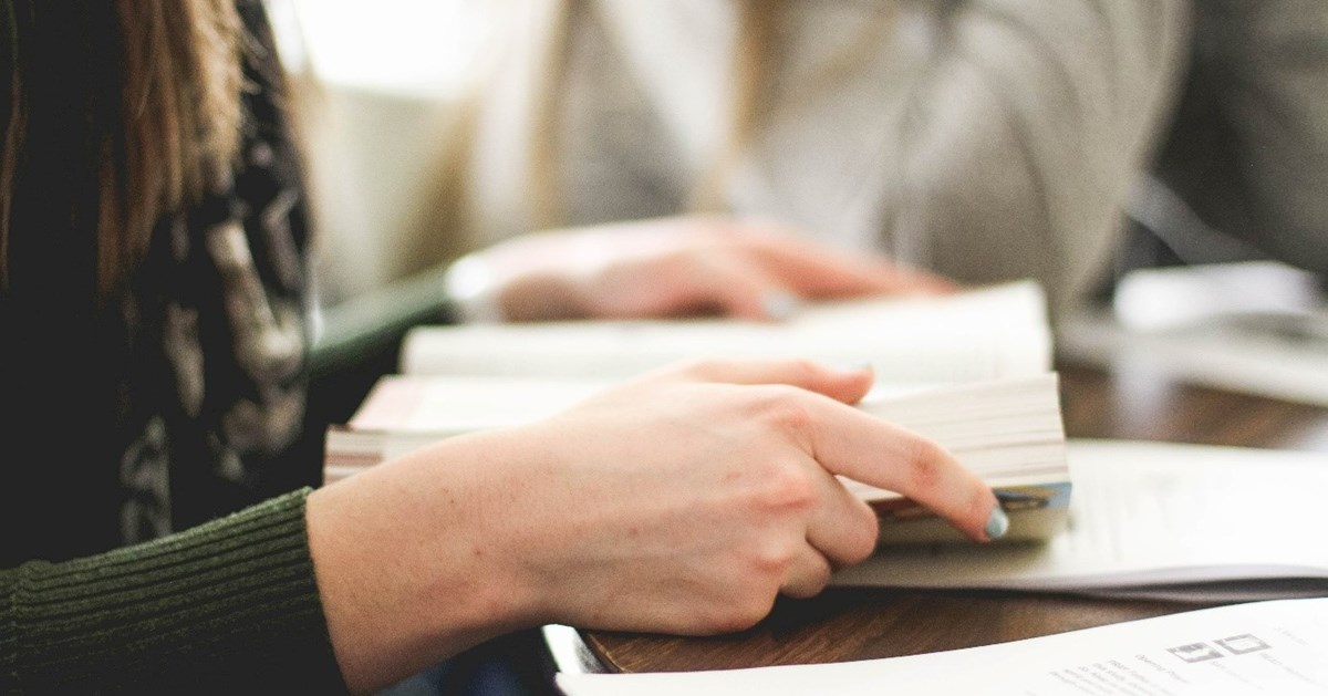 Hender som holder en bok