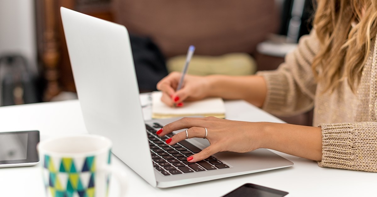 Hender skriver på laptop
