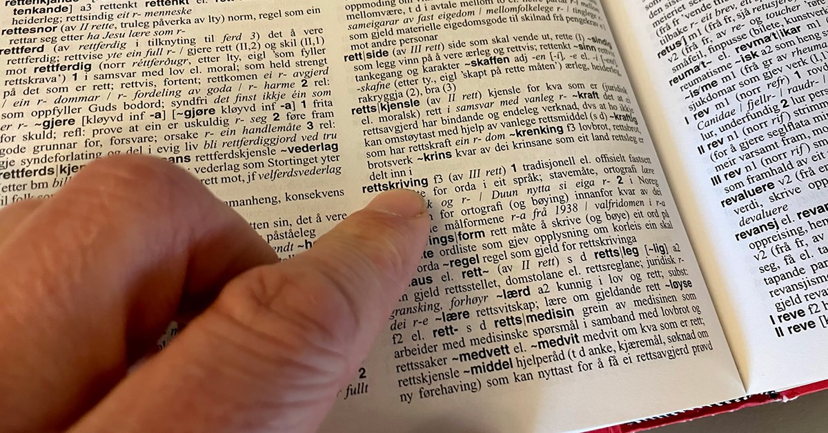 Finger som peker på ordet 